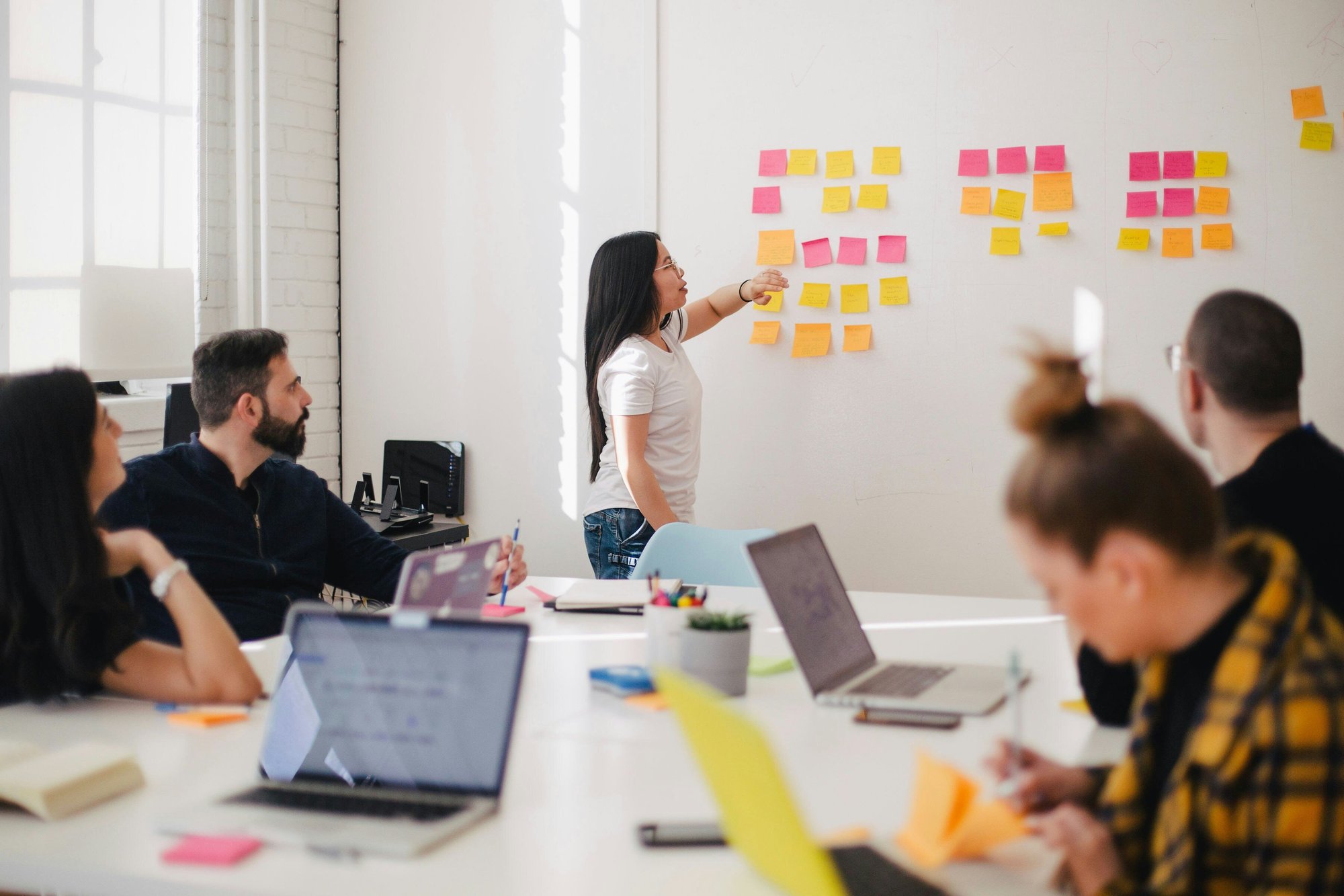 People sitting at a table brainstorming with post-it notes